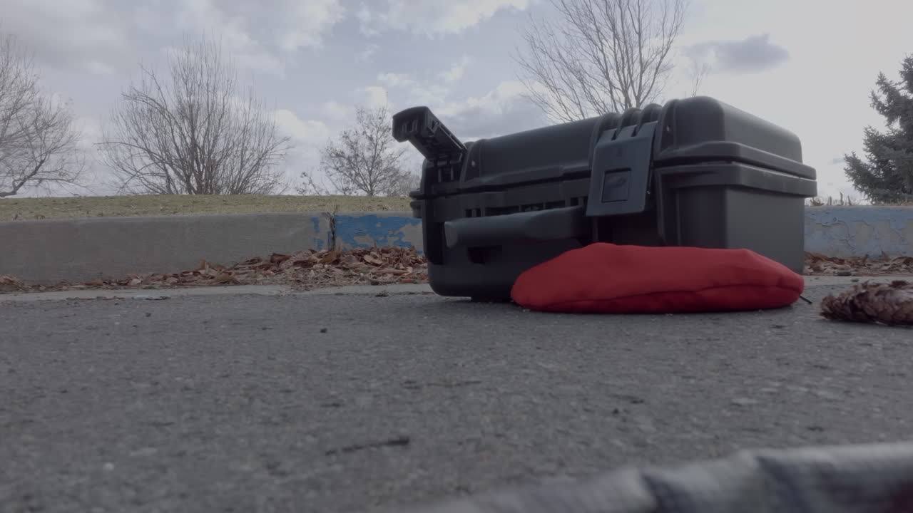 작은 하드 케이스가 주차장에 부분적으로 열려 있습니다.