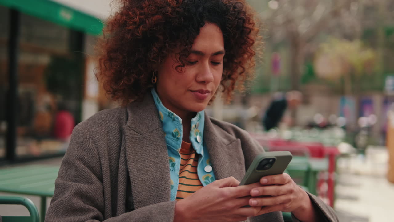 Woman Using Smartphone Outdoors at a Cafe