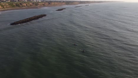 Toma-Aérea-En-órbita-De-Una-Persona-Con-Kayak-Remando-En-El-Amplio-Océano-Atlántico-Frente-A-Los-Acantilados-En-Los-Acantilados-De-Mar-Del-Plata-Durante-La-Hermosa-Puesta-De-Sol