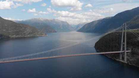 drone view of suspension bridge that spans a fjord