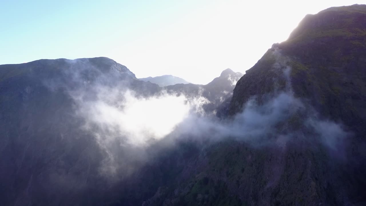 포르투갈 마데라 - 밝고 은 날씨에 푸른 하늘 아래 산꼭대기를 둘러싼  구름 - 공중 드론 촬영