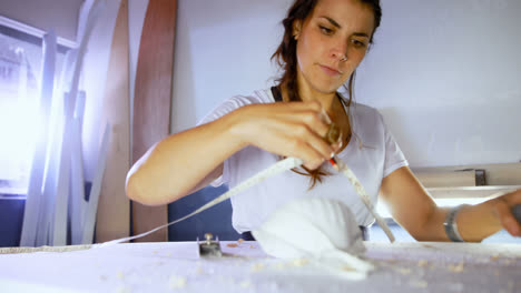 mujer y hombre haciendo tabla de surf en el taller 4k