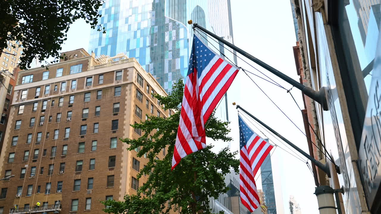 New York, USA, 1 agosto 2025: bandiere americane sugli edifici di Manhattan. File di bandiere americane che sventolano orgogliosamente tra i grattacieli storici e moderni di New York
