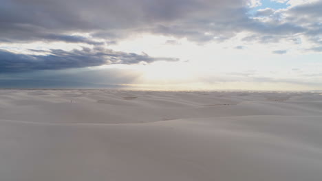 antena de 4k del hermoso campo interminable de dunas de arena blanca con personas a escala