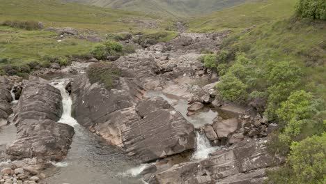 drone shot of a meandering rocky riverbed through ireland's lush countryside