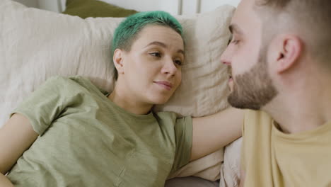 loving couple talking together and relaxing on the bed at home