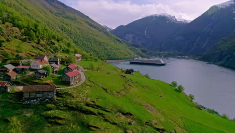 A-luxury-cruise-ship-docks-in-Flam,-Norway's-stunning-landscape---aerial