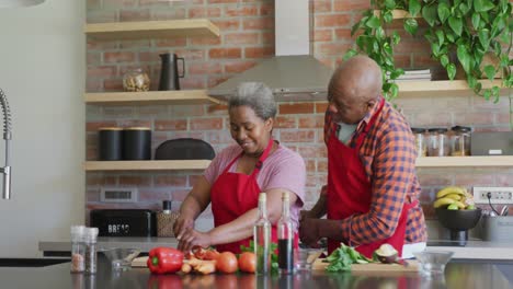 Glückliches-Afroamerikanisches-Seniorenpaar,-Das-Gemeinsam-In-Der-Küche-Kocht