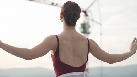 young woman dancing outside near construction crane