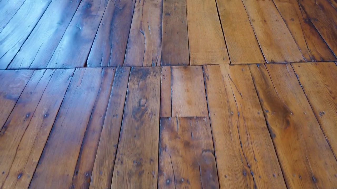 Eikegulvplanker fra Aston Hall sett fra et lavt, fremovergående kamera, som avslører slitte treplanker og patina inne i det jakobinske herregården i Birmingham, England