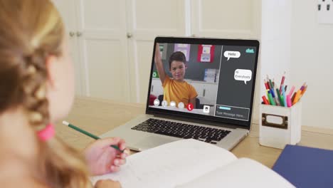 Schoolgirl-using-laptop-for-online-lesson-at-home,-with-boy-raising-hand-and-web-chat-on-screen