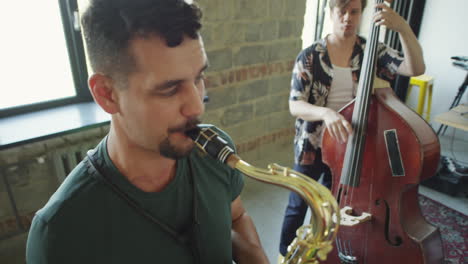 a musical band playing drums, double bass, and saxophone during a practice session