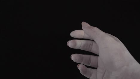 검정색 배경에서 부드럽게 움직이는 흰색으로 칠해진 젊은 여성 손