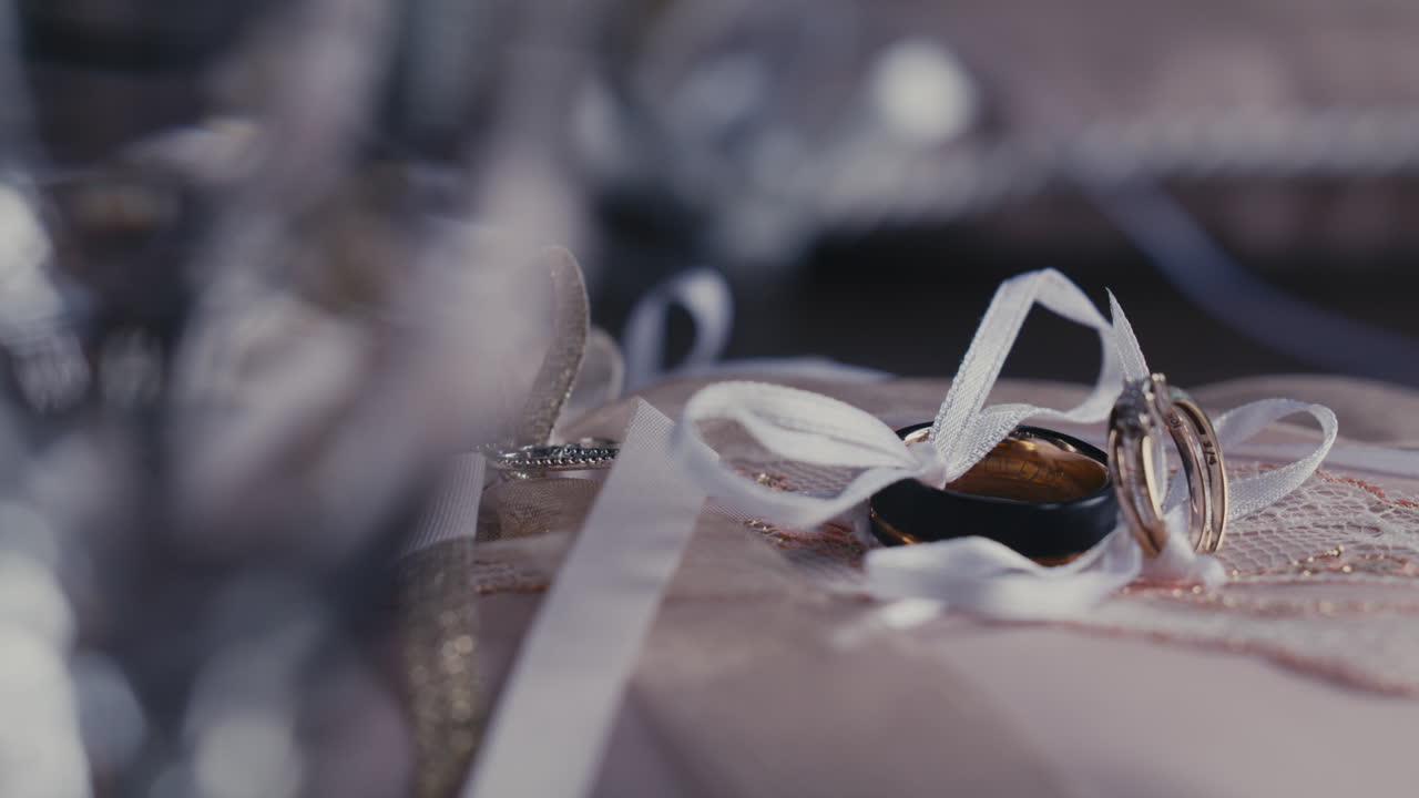 Par de anillos de boda atados con una cinta blanca