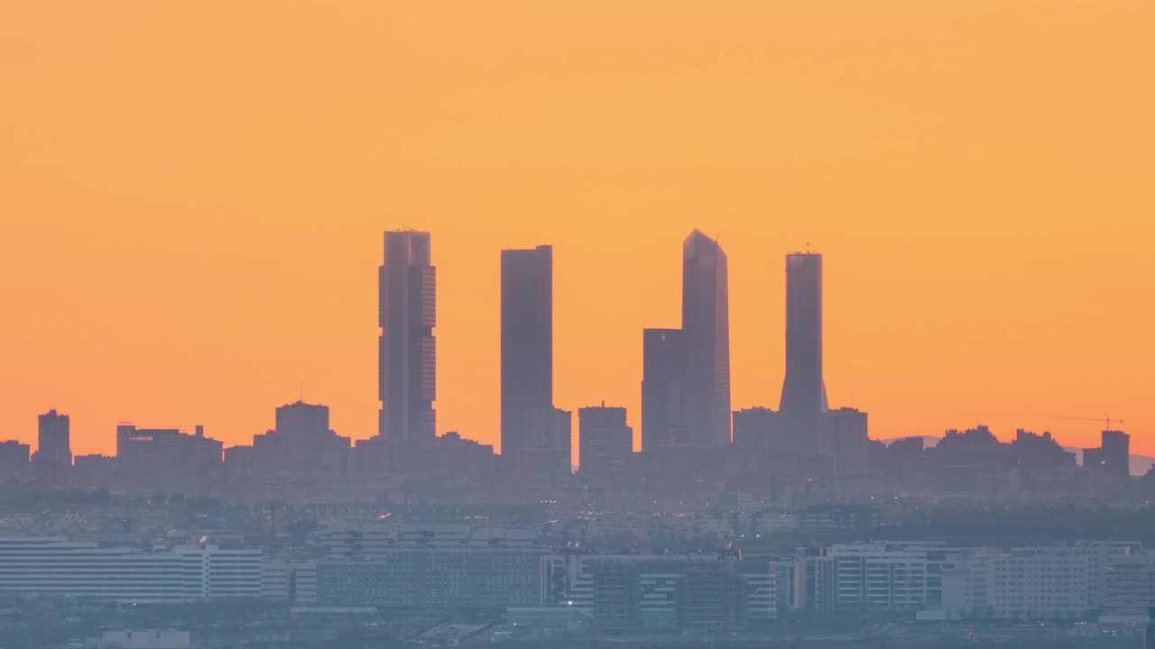 Timelapse sun setting behind Madrid skyline towers silhouete during colorful sunset