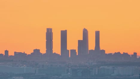 Timelapse-sun-setting-behind-Madrid-skyline-towers-silhouete-during-colorful-sunset