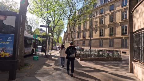 couple walking past bus stop in paris