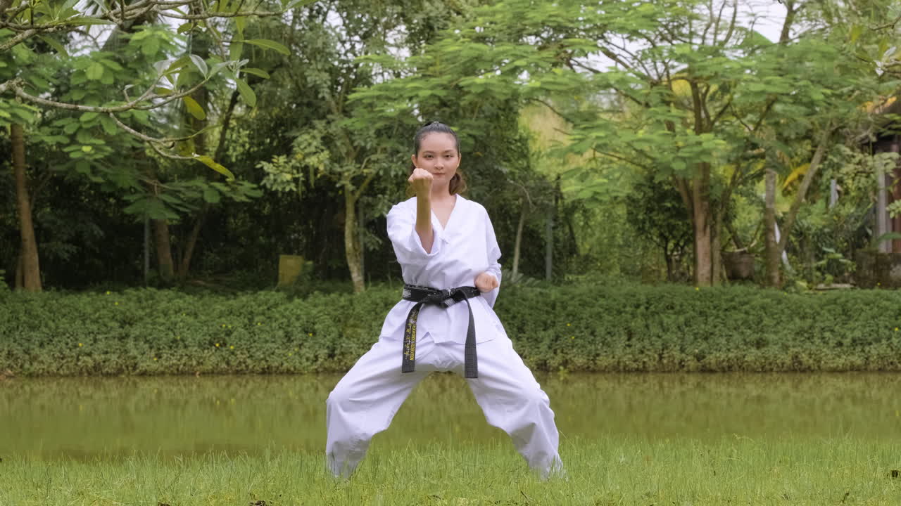 una mujer joven practicando taekwondo.