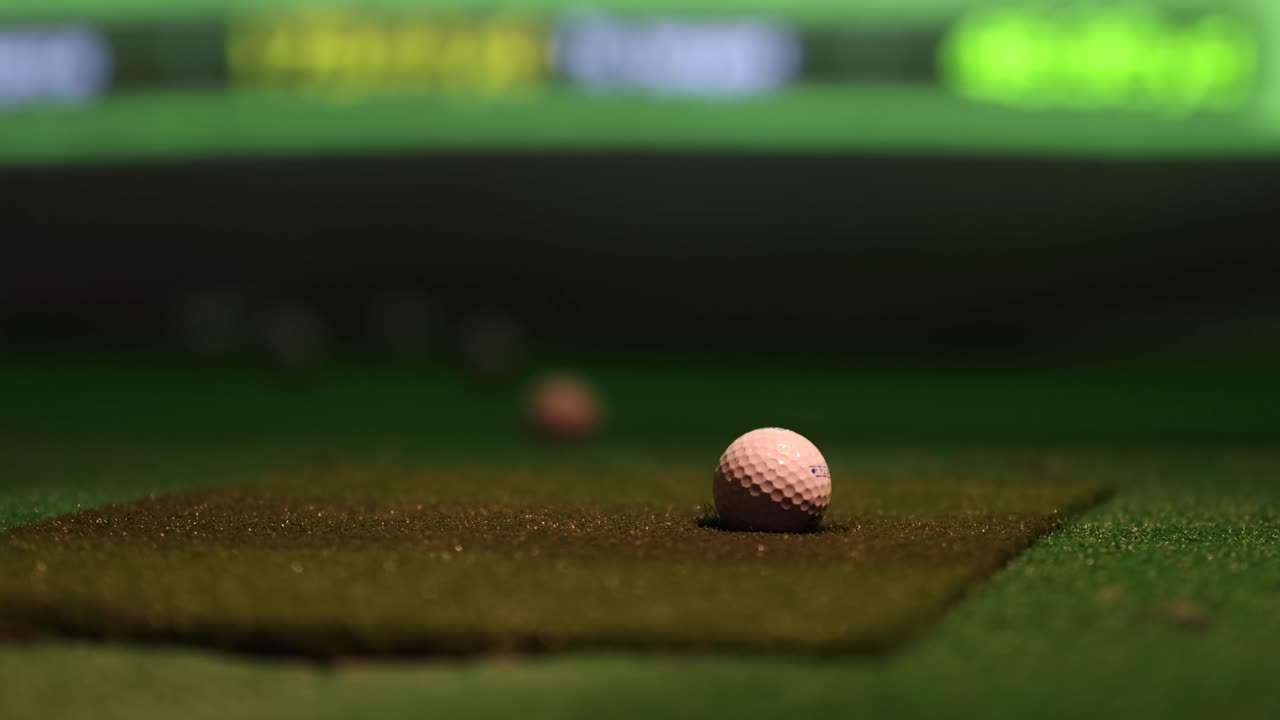 Primo piano di una pallina da golf che rotola fluidamente sulla superficie di un putting green.