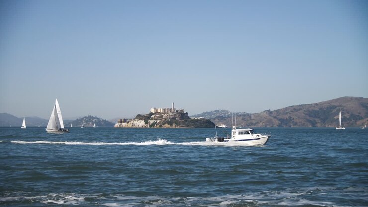 impresionante vista de 4k de la famosa prisión de alcatraz en san francisco con clima soleado y barcos y yates conduciendo - san francisco lugares para ver turismo - hermoso día