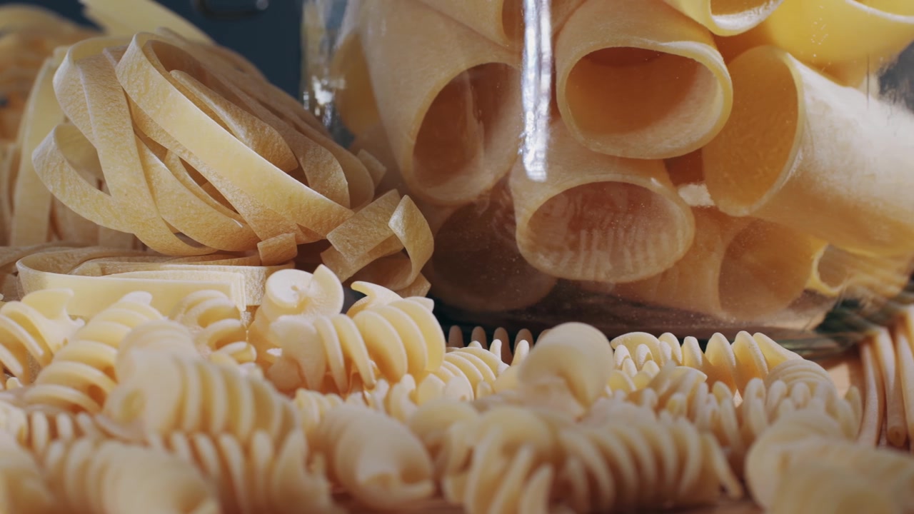 Close-up of Various Uncooked Italian Pasta Types on a Wooden Surface