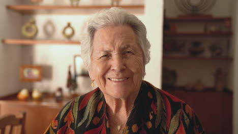 senior smiling woman in warm shawl in dining room