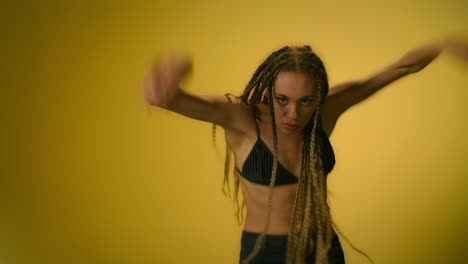 Mujer-Flexible-Mostrando-Elementos-De-Danza-Moderna-En-Estudio-Sobre-Fondo-Amarillo.