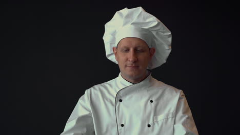 male chef with large knives, ready to cook. medium shot on black background.