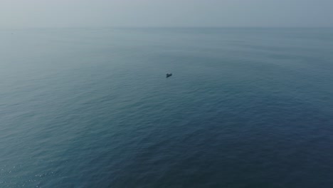 vista aérea en cámara lenta de un pequeño barco de pesca en el tunco el salvador