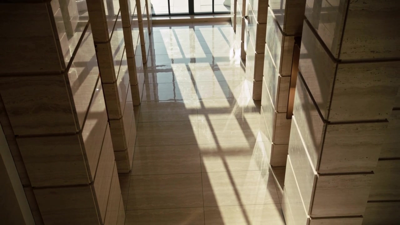 Shifting sun angle moving window-grid shadow across polished corridor floor in atrium, with columns
