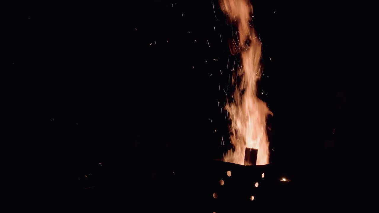 Cinematic shot of fire flame with sparks on windy day,medium shot