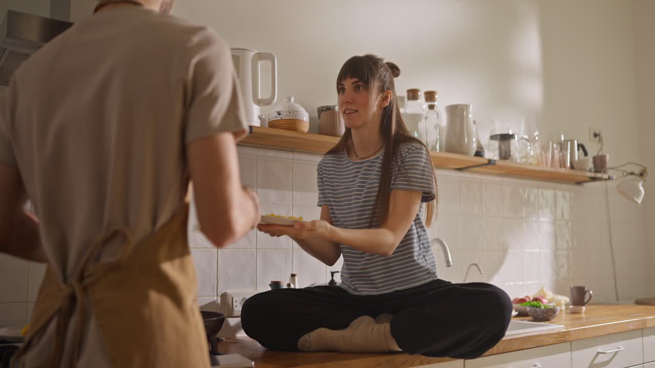 Couple cooking breakfast in kitchen