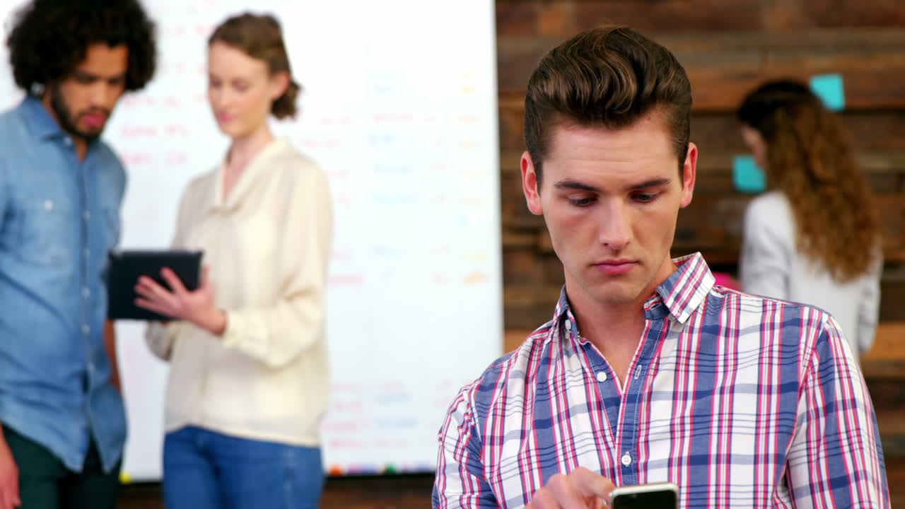 ejecutivo de negocios usando teléfono móvil en una reunión