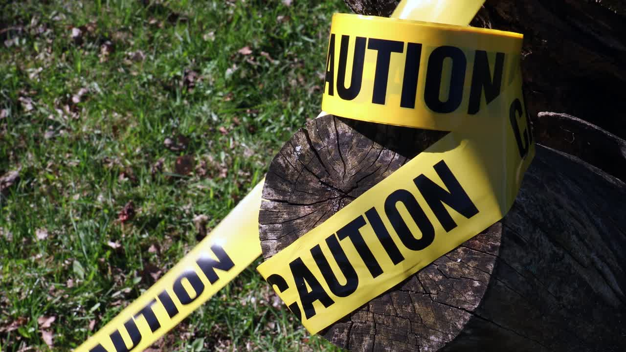 Warning for caution written on yellow ribbon