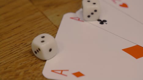 Extreme-Nahaufnahme-Von-Texas-Holdem-karten-Mit-Pik-Wie-In-Rot-Und-Schwarz,-Die-Würfel-Auf-Einem-Hochwertigen-Holztisch-Spielen