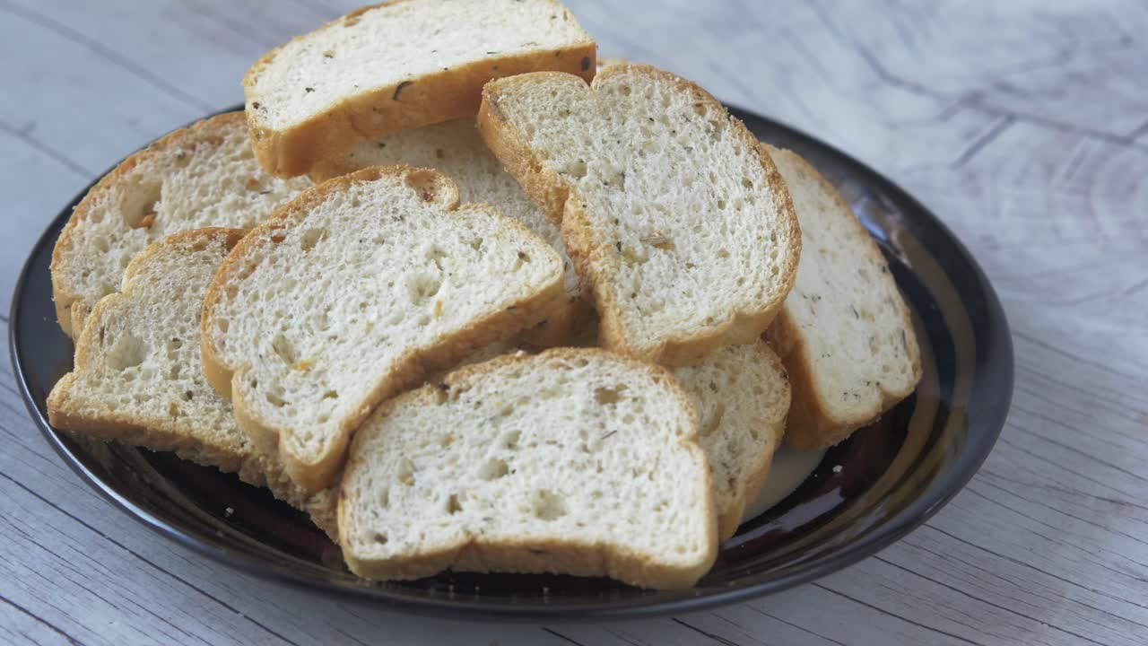 Pile of toasted bread slices on a dark plate