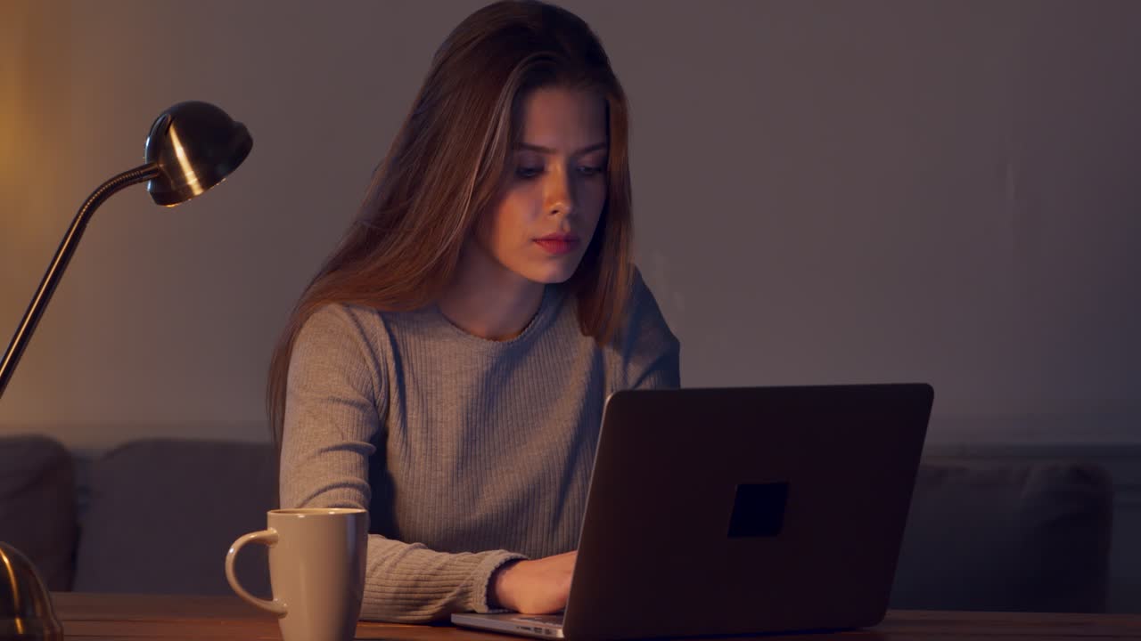 mujer joven trabajando en la computadora portátil por la noche