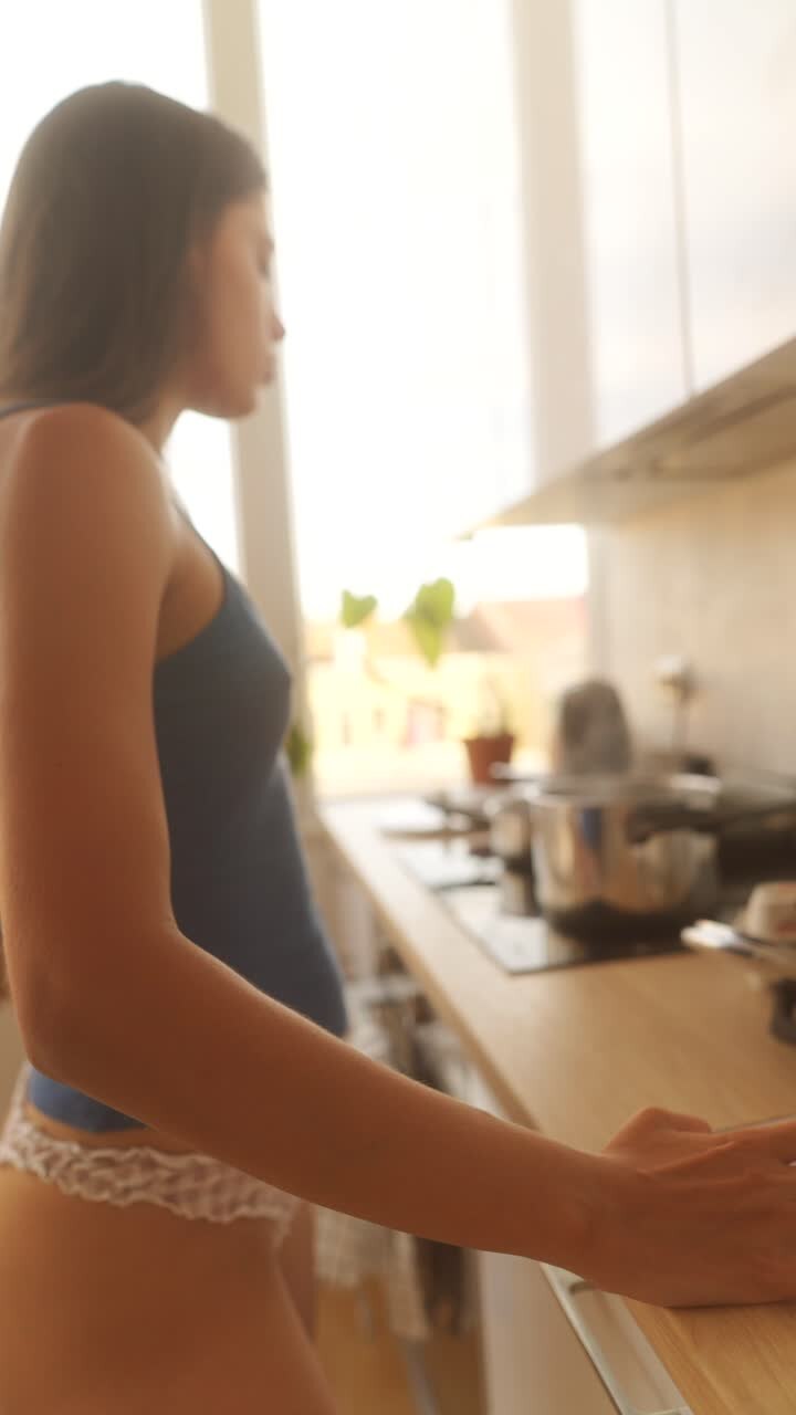 Giovane donna in piedi in una cucina