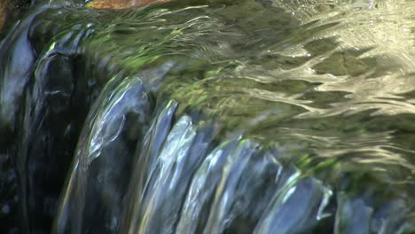 close-up of water flowing over the brink of a small waterfall