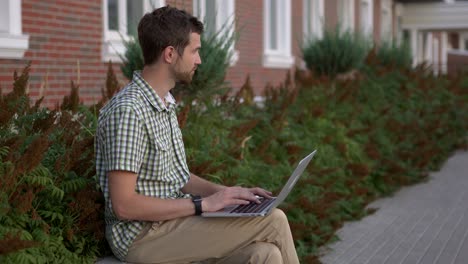 hombre trabajando en una computadora portátil al aire libre