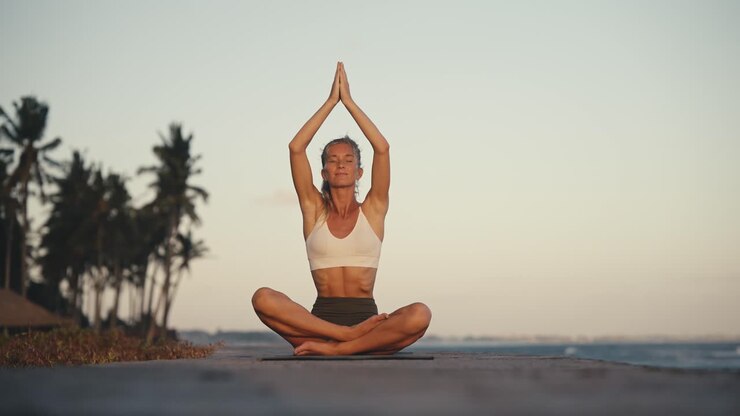 Mujer meditando en postura del loto con las manos juntas en namaste, concepto de yoga.