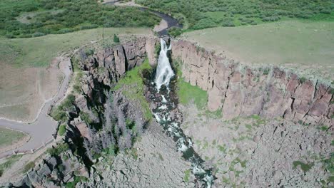 Aerial-view-of-a-big-waterfall-in-a-green-canyon-in-Colorado