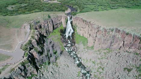 aerial view of a big waterfall in a green canyon in colorado