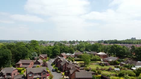 Suburban-woodland-red-brick-British-townhouse-development-neighbourhood-aerial-view-flying-above-detached-property