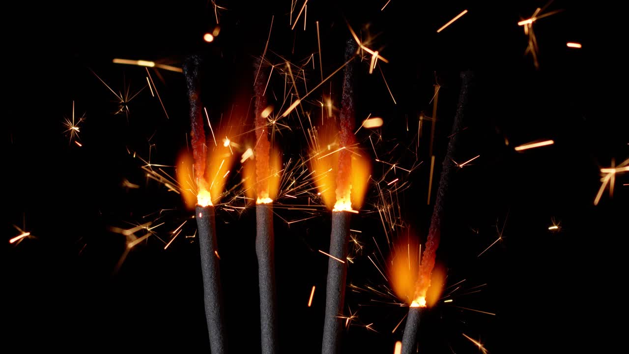 Bengal fires, New Year sparkler candles, sparkling lights burning on a black background, slow motion