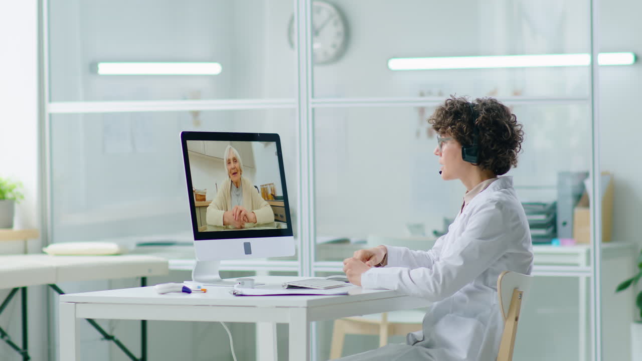 Female Doctor Consulting with Elderly Woman via Web Call