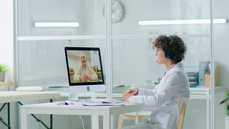 female doctor consulting with elderly woman via web call