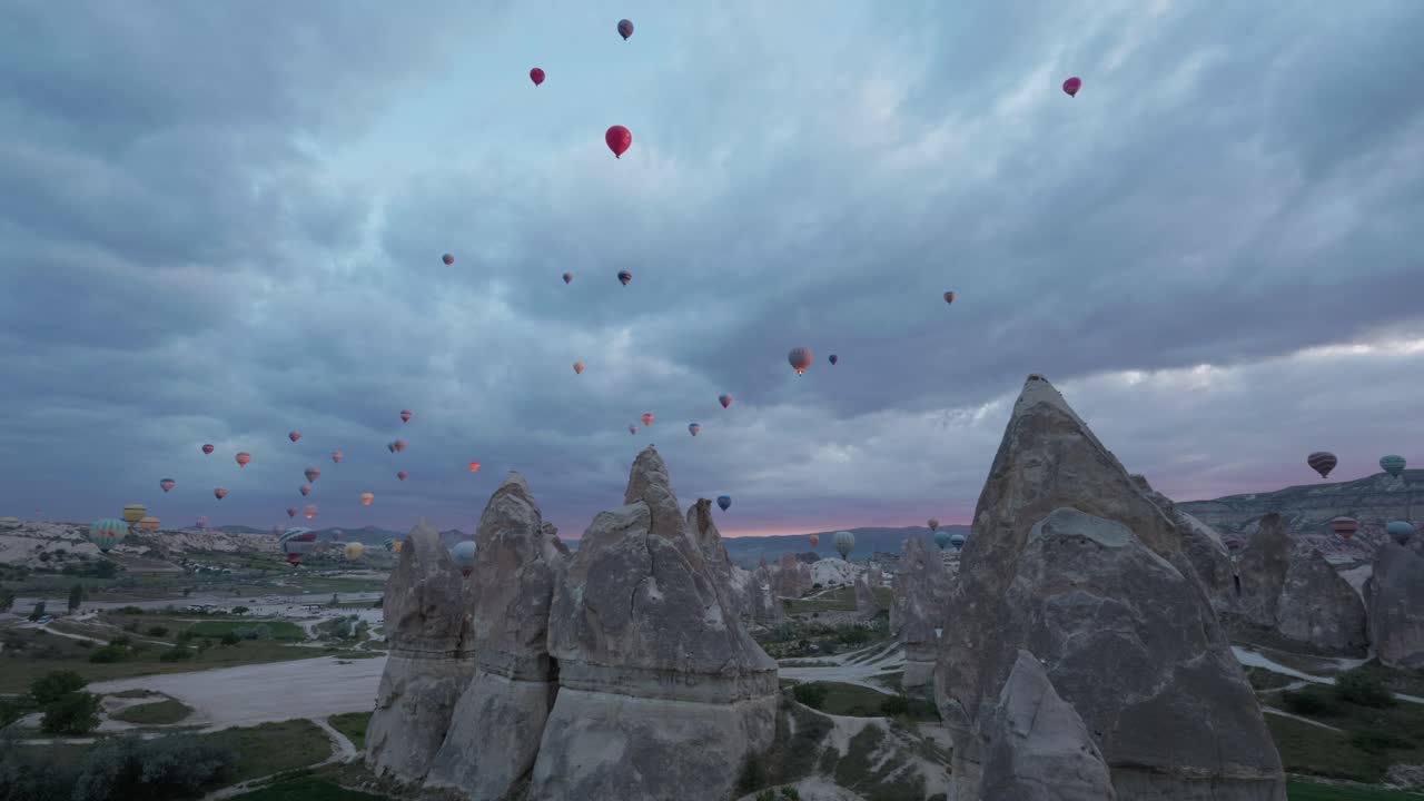 los globos de aire caliente llenan el cielo sobre las impresionantes estructuras geológicas de capadocia.