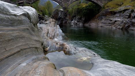 pan up to ponte dei salti roman arched bridge crosses river in lavertezzo verzasca switzerland