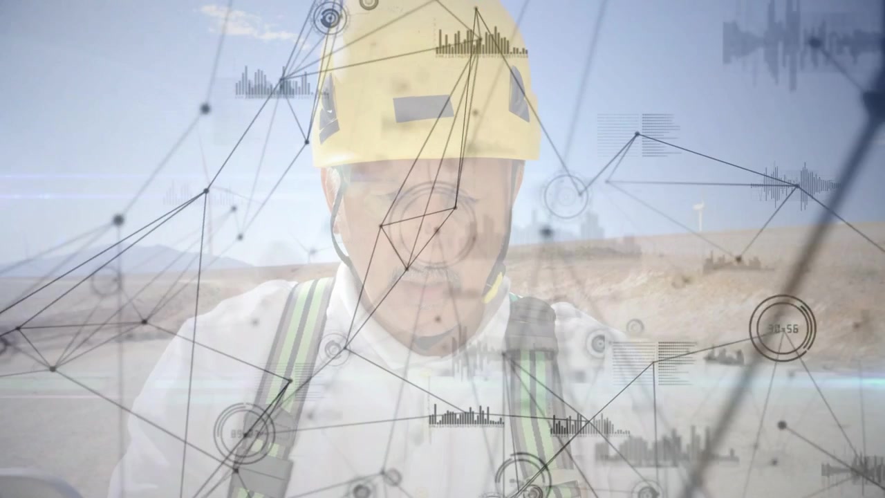 Mature male worker standing at desert site with yellow hard hat harness, digital overlays sweeping